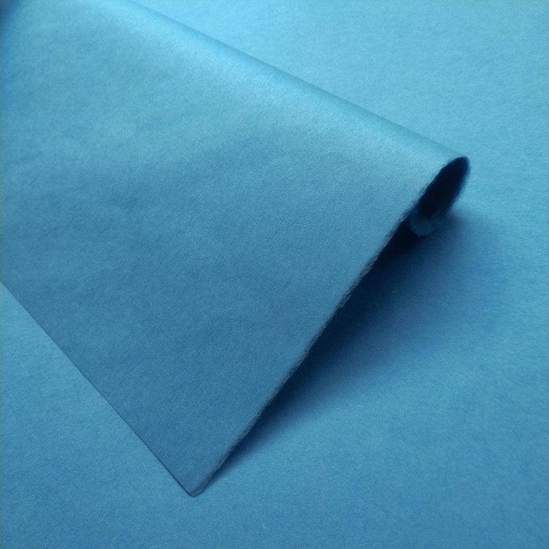 Solid-colored handmade paper in cobalt blue from Kozo Studio shown in detail, showcasing the soft texture of premium mulberry paper.