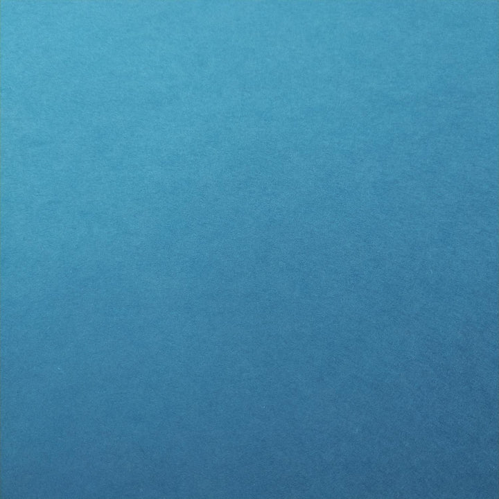 Kozo Studio mulberry paper in vibrant cobalt blue with lighting that emphasizes the fine grain of handmade paper sheets.
