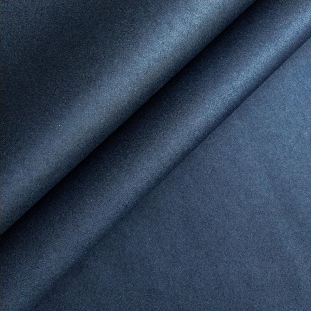 Close-up of denim blue handmade paper by Kozo Studio featuring smooth mulberry paper texture and gentle lighting.