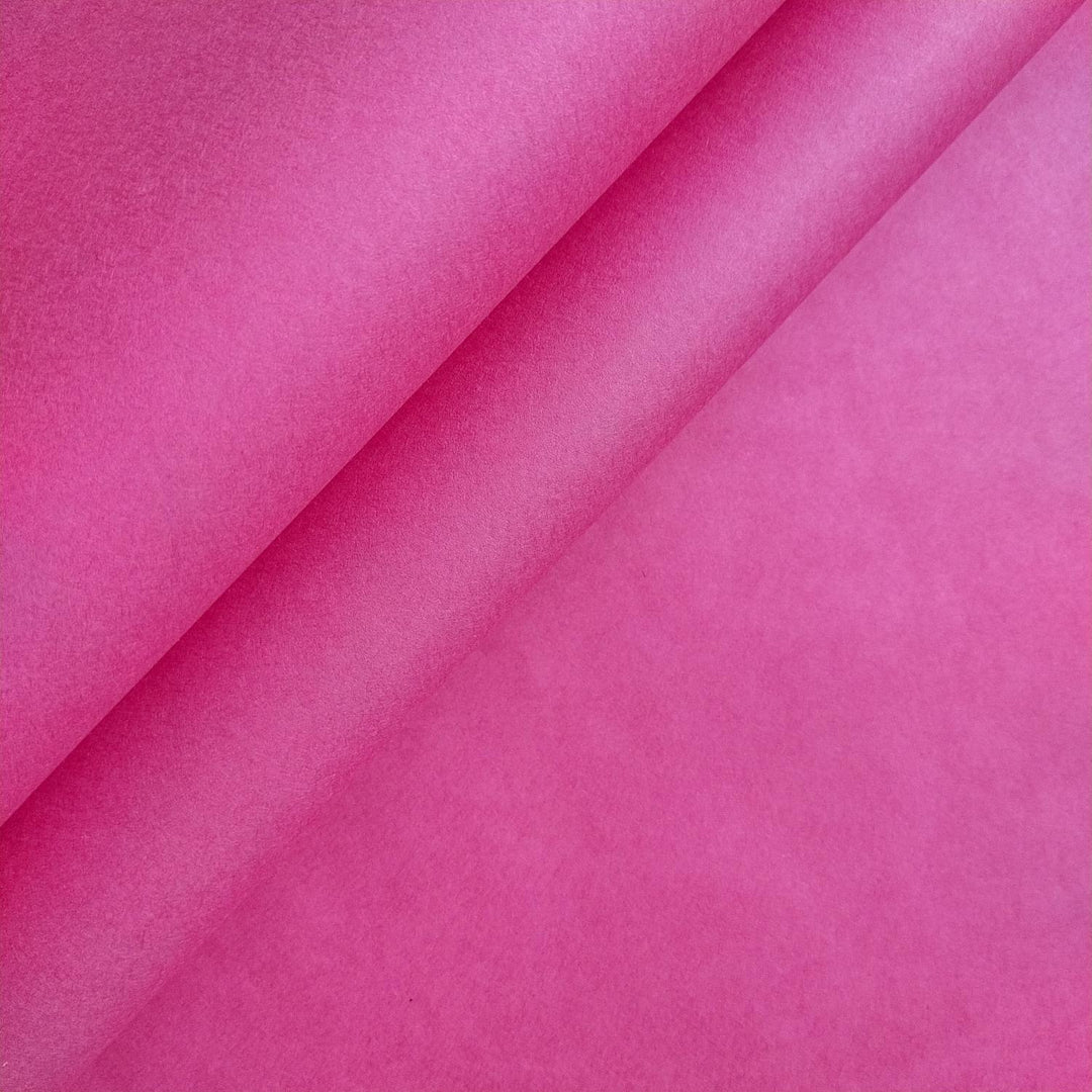 Close-up of fuchsia mulberry paper by Kozo Studio, highlighting its vibrant pink tone and subtle texture, perfect for handmade paper projects.