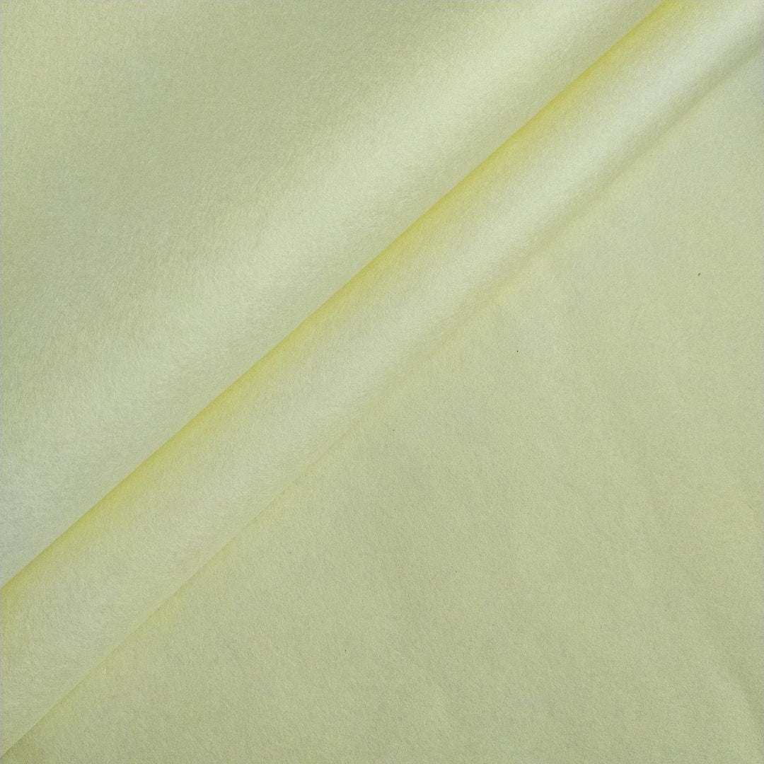 Close-up of lemon yellow handmade mulberry paper from Kozo Studio, showing its smooth texture and soft folds in a diagonal layout.