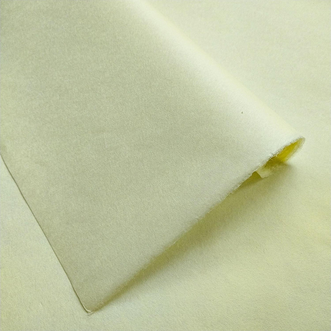 Solid-colored Kozo Studio mulberry paper in lemon yellow, captured at an angle to highlight its delicate texture and gentle sheen.