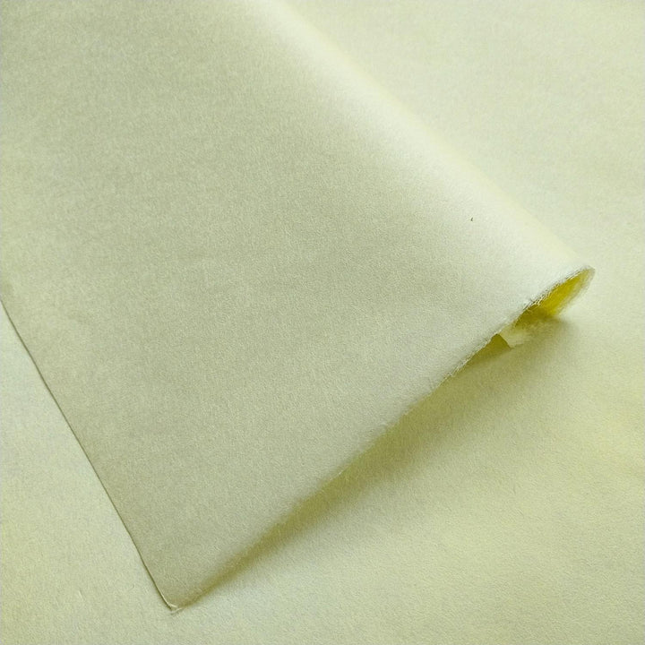 Solid-colored Kozo Studio mulberry paper in lemon yellow, captured at an angle to highlight its delicate texture and gentle sheen.