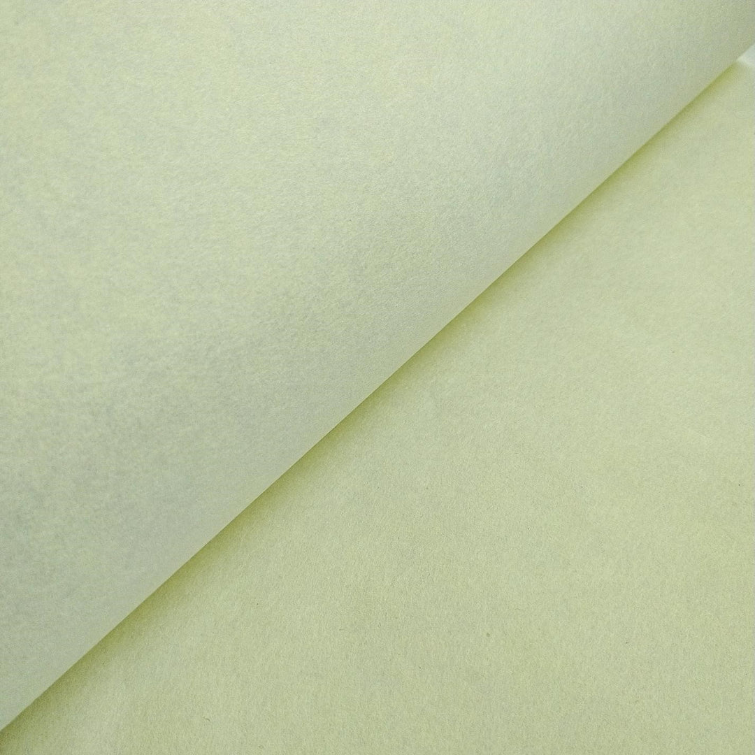 Detail of Kozo Studio lemon yellow mulberry paper, emphasizing its subtle sheen, handmade quality, and folded presentation.