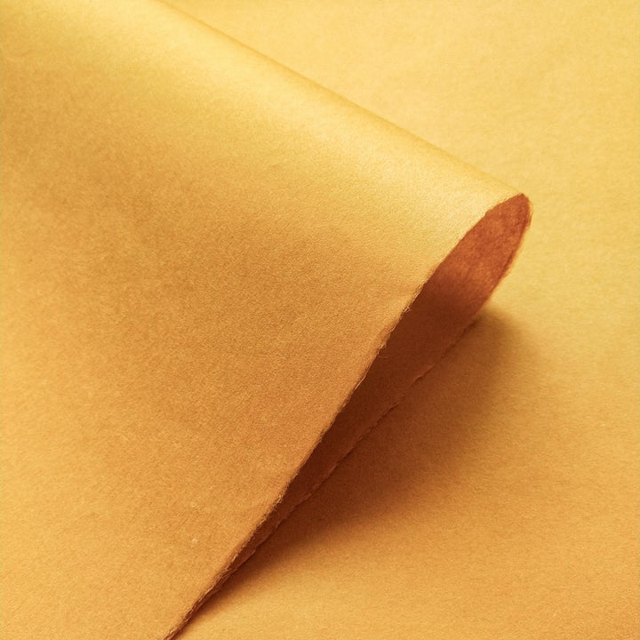 Orange Kozo Studio handmade paper in solid Nugget color, featuring layered textures that reflect the warmth and depth of quality mulberry paper.
