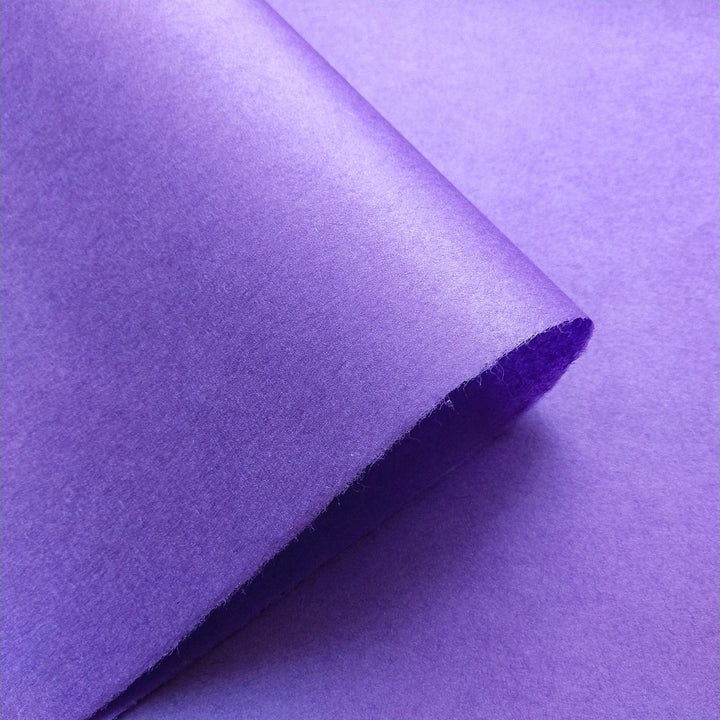 Purple handmade paper by Kozo Studio featuring a smooth surface and natural grain highlights in varied shades.