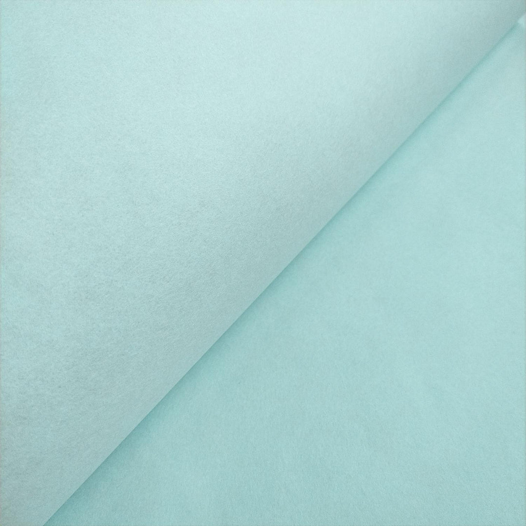 Elegant matte finish of Kozo Studio mulberry paper, shown in a close-up of the sky blue sheet folded for depth and texture.