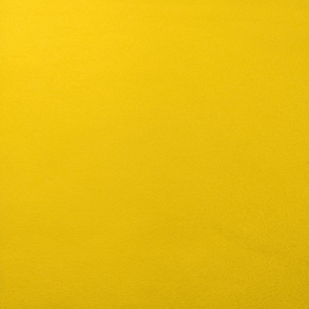 Diagonal fold in Kozo Studio's solid-colored handmade mulberry paper, glowing in bright yellow with subtle layered shading.