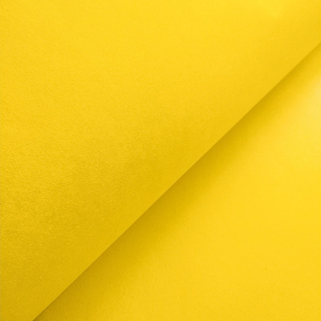 Vivid canary yellow handmade paper from Kozo Studio, crafted from mulberry fibers and artistically folded for texture and contrast.