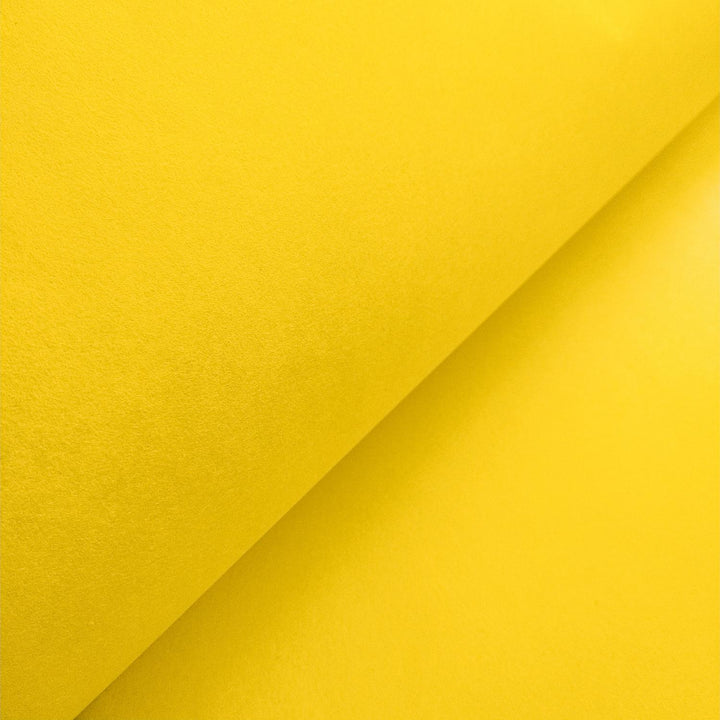 Vivid canary yellow handmade paper from Kozo Studio, crafted from mulberry fibers and artistically folded for texture and contrast.