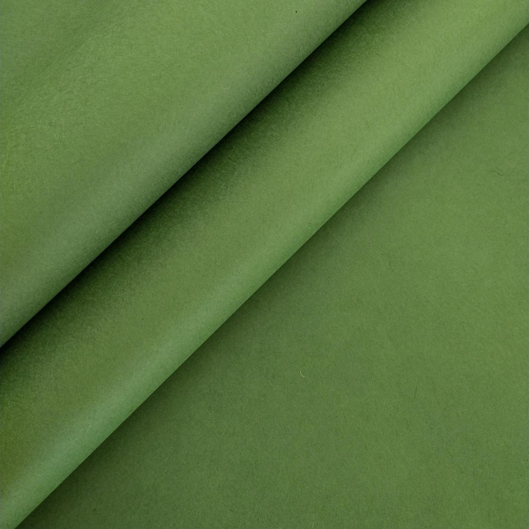 Close-up of fern green handmade paper from Kozo Studio with smooth texture mulberry paper, featuring gentle folds that create soft shadows and highlights.
