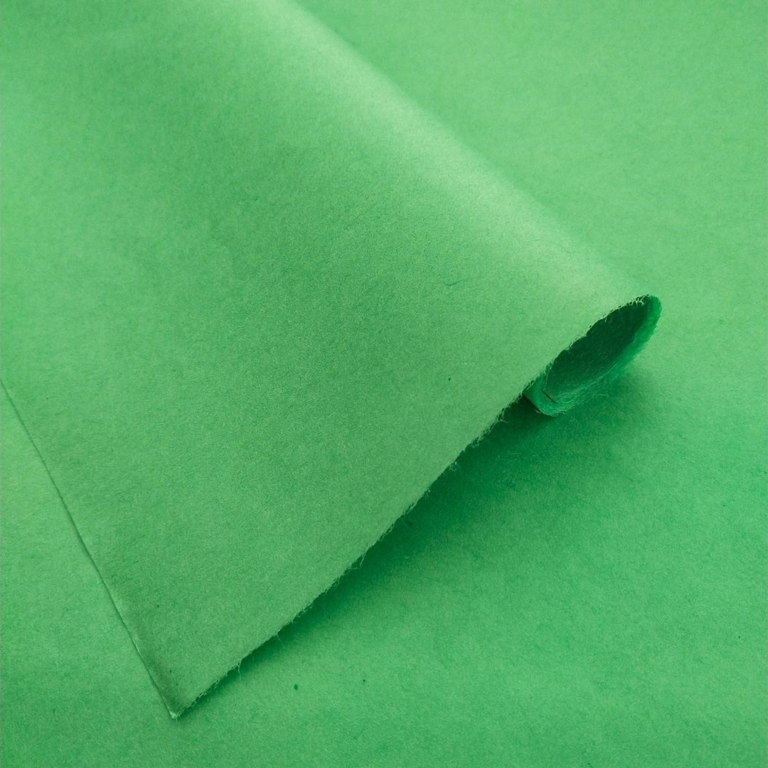 Detailed view of solid-colored mulberry paper in forest green, crafted by Kozo Studio and folded to display its elegant handmade texture.