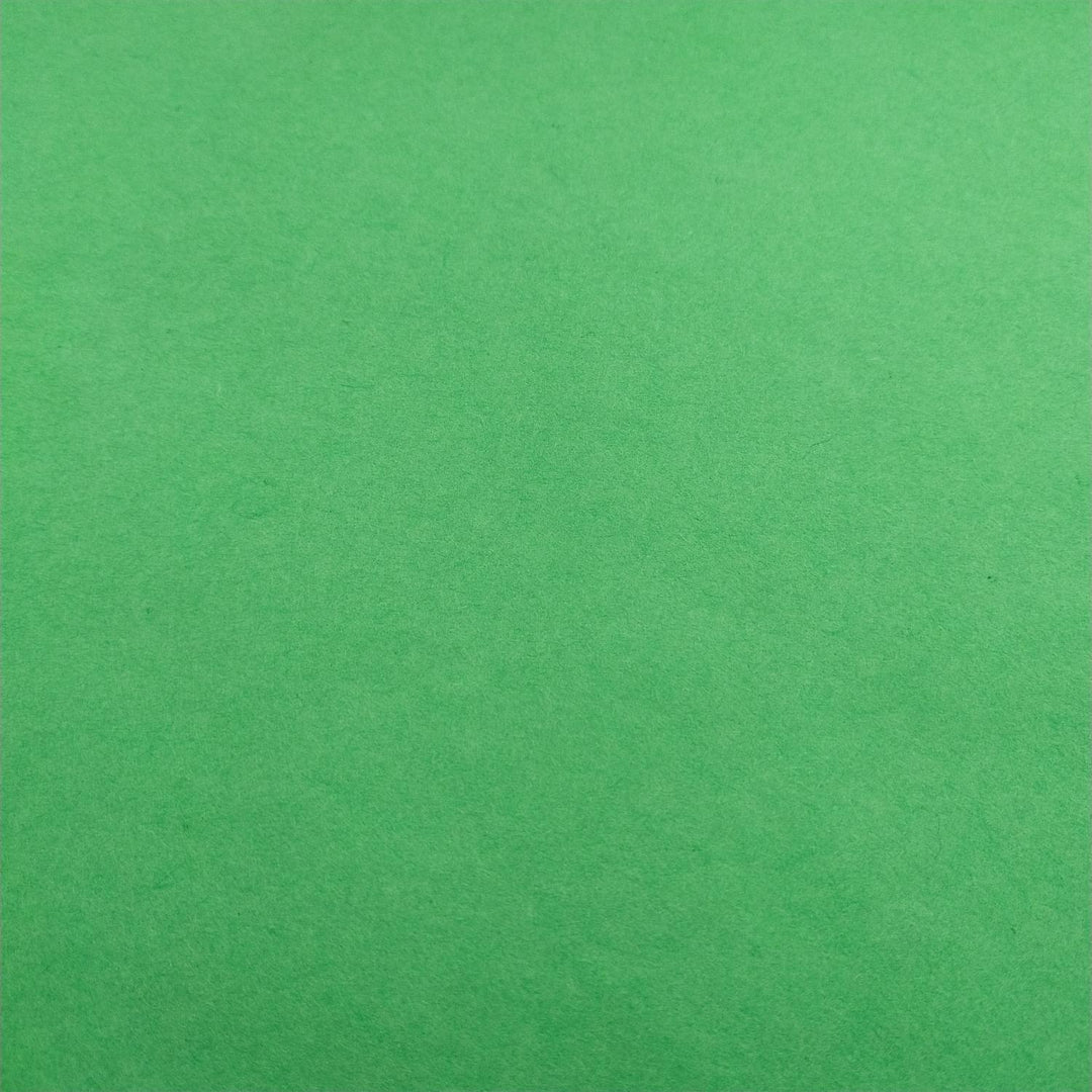 Handmade mulberry paper in forest green by Kozo Studio, neatly folded to reveal its natural fibers and soft, luxurious texture.