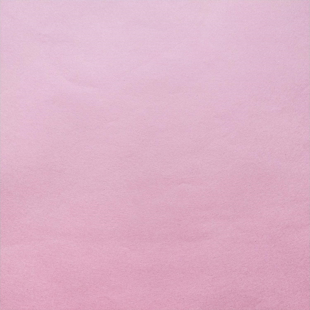 Detailed view of classic pink handmade paper by Kozo Studio with visible fibers and soft shadows enhancing the mulberry texture.