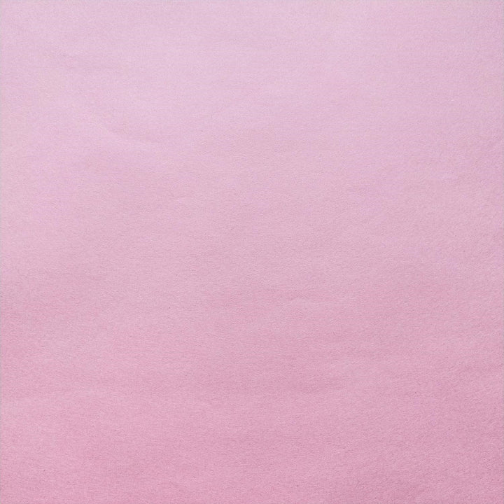 Detailed view of classic pink handmade paper by Kozo Studio with visible fibers and soft shadows enhancing the mulberry texture.