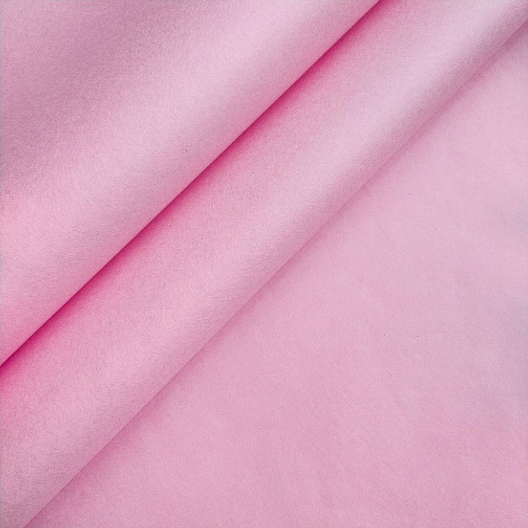Close-up of classic pink mulberry paper from Kozo Studio showing the soft texture and delicate curves of handmade paper.
