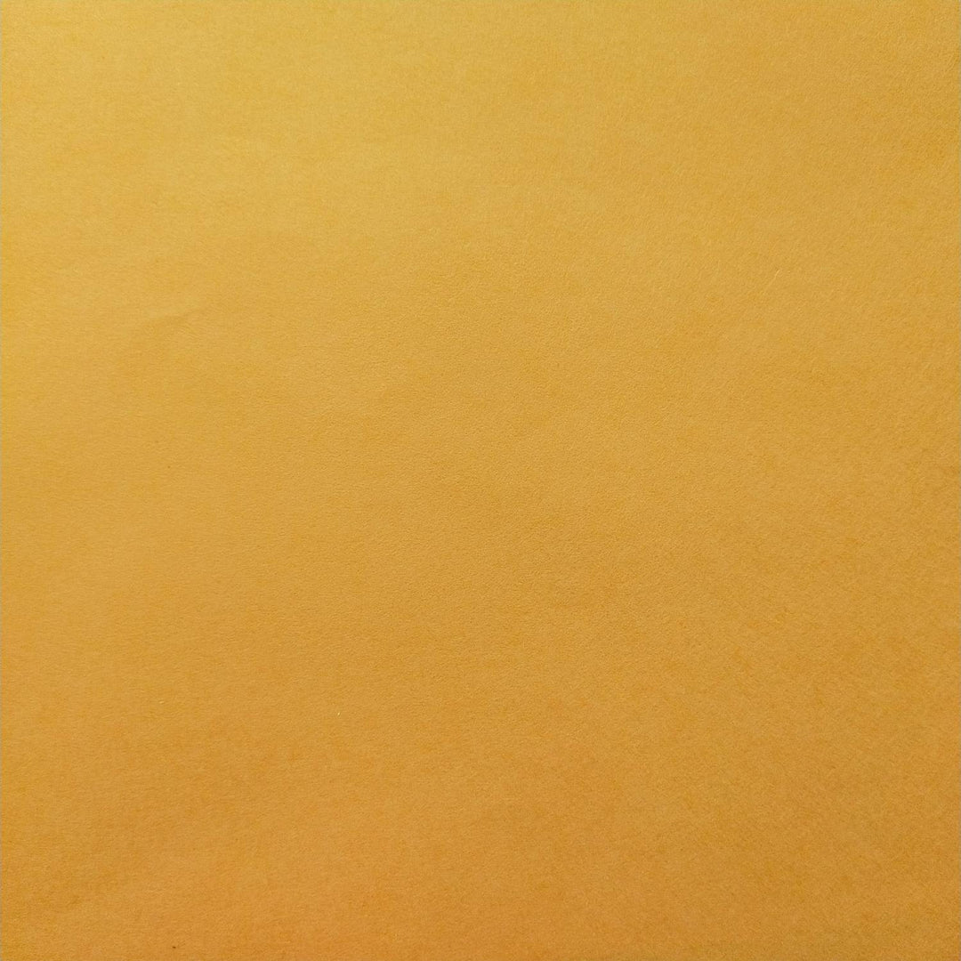 Saffron mulberry paper from Kozo Studio captured in a close-up image that emphasizes its textured surface and smooth color transitions, typical of high-quality handmade paper.