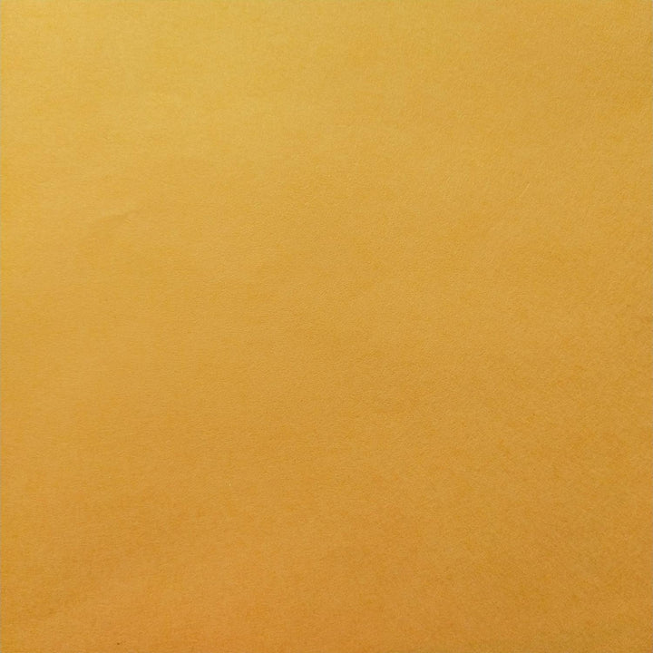 Saffron mulberry paper from Kozo Studio captured in a close-up image that emphasizes its textured surface and smooth color transitions, typical of high-quality handmade paper.
