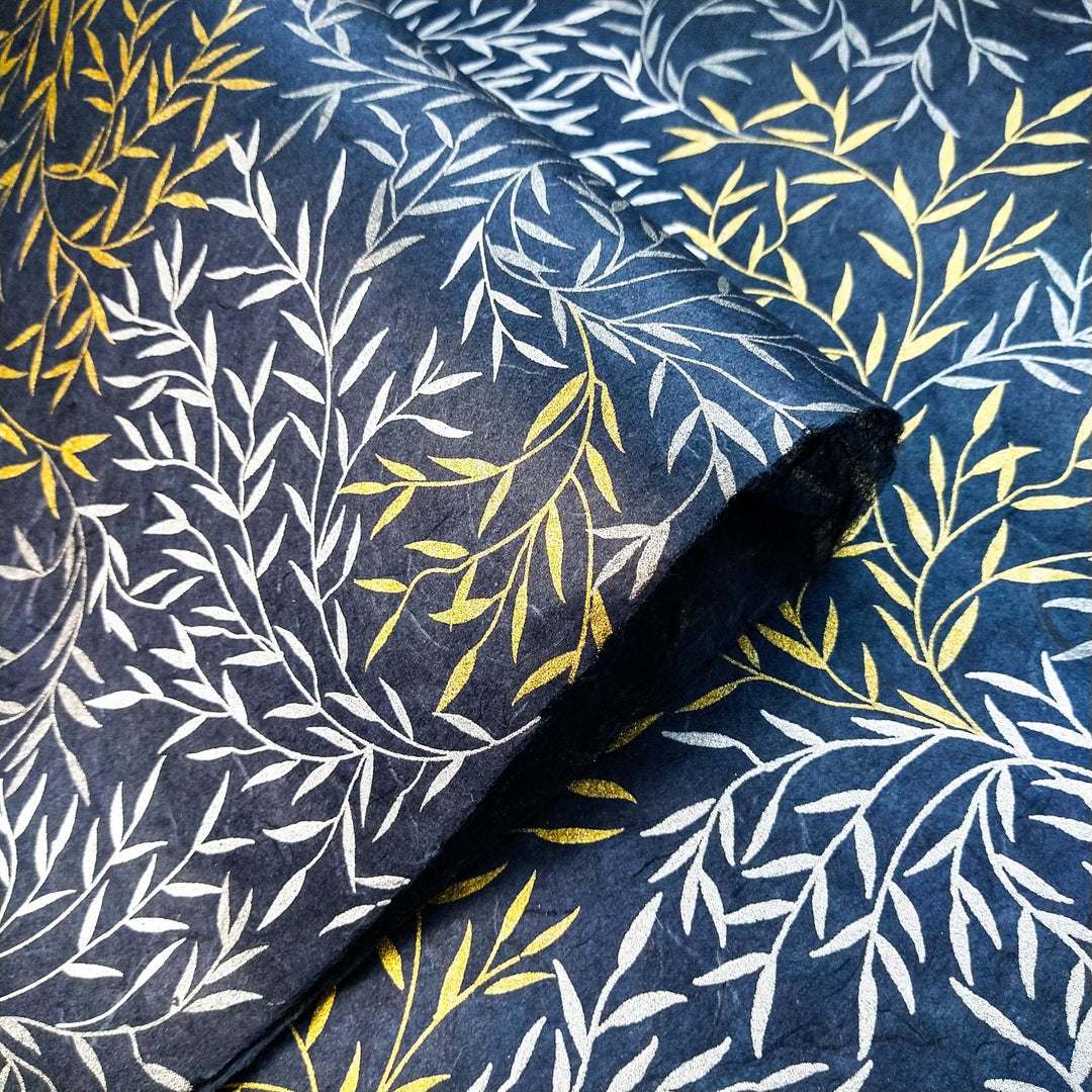 Screen-printed mulberry paper from Kozo Studio with layered gold, silver, and white foliage on dark blue, blending texture and elegance in handmade paper design.
