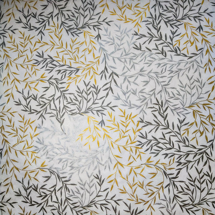 Detailed view of Kozo Studio's screen-printed mulberry paper with reflective gold and silver leaf motifs on a soft white handmade paper background.