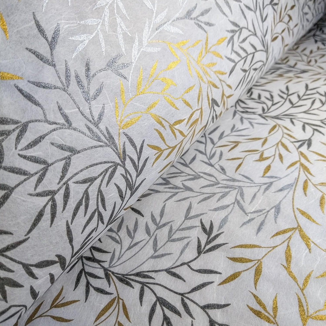 Elegant mulberry paper crafted by Kozo Studio, featuring shimmering metallic prints of leaves in silver and gold on handmade white paper.