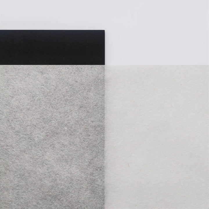 An abstract black and white image showcases a gray-textured area on the left, inspired by A4 Extra Thin Natural Kozo Paper from Kozo Studio, a black strip on top, and a smooth white section on the right, intersecting at vertical and horizontal lines.