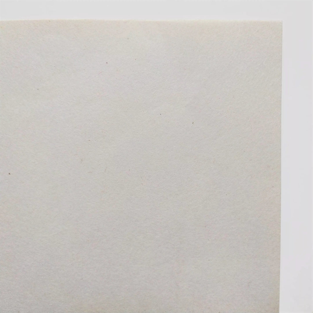 Textured surface of uncoated mulberry paper by Kozo Studio, ideal for inkjet printing, calligraphy, or decoupage; the handmade paper curls softly on a white backdrop.