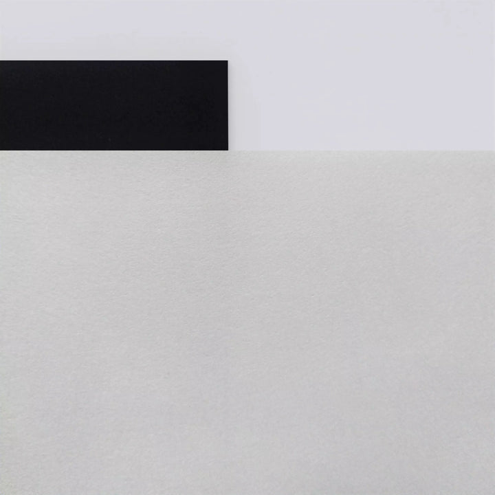 A black rectangle overlaps the top edge of a large white textured surface, evoking calligraphic art on Kozo Studio’s Thick White Kozo Paper Roll (200 gsm), all arranged on a smooth light gray background in a minimal, geometric style.