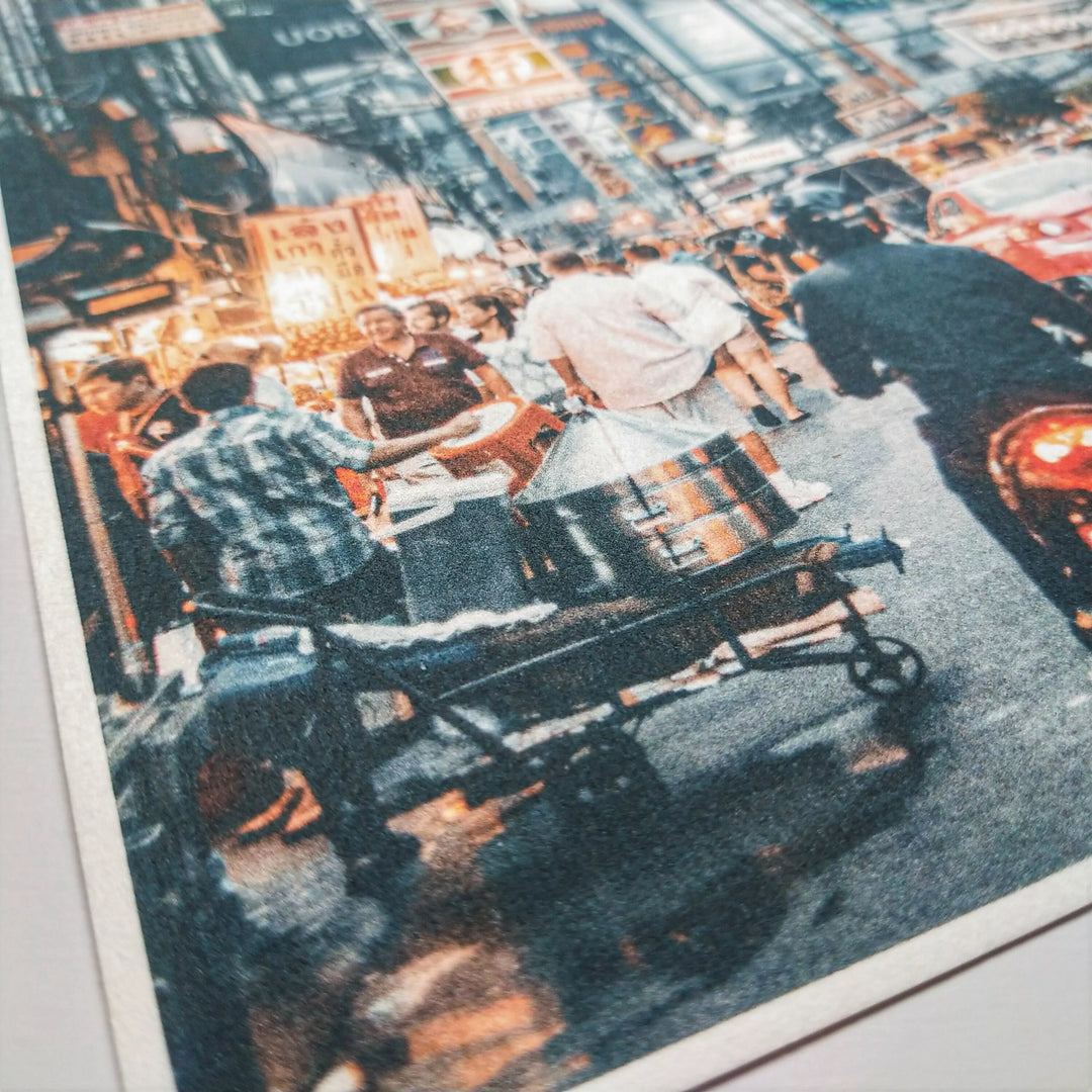 A bustling city street scene with people and bright shop lights offers perfect inspiration for calligraphy or drawing on Kozo Studio’s Thick White Kozo Paper Roll (200 gsm).