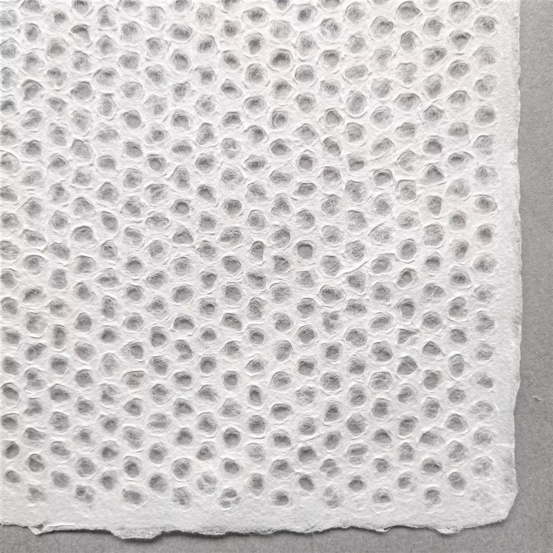Textured Surface of Handmade Mulberry Paper from Kozo Studio – This lace-style Kozo paper demonstrates expert craftsmanship using the Rakusui technique to create intricate, airy designs.