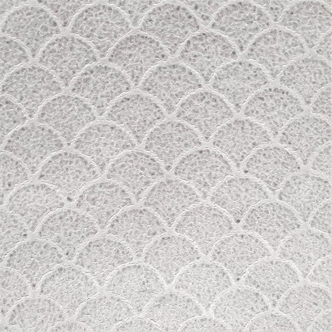 Detailed view of wave-patterned handmade mulberry paper from Kozo Studio, showcasing its raised texture and natural edges on a matching surface.