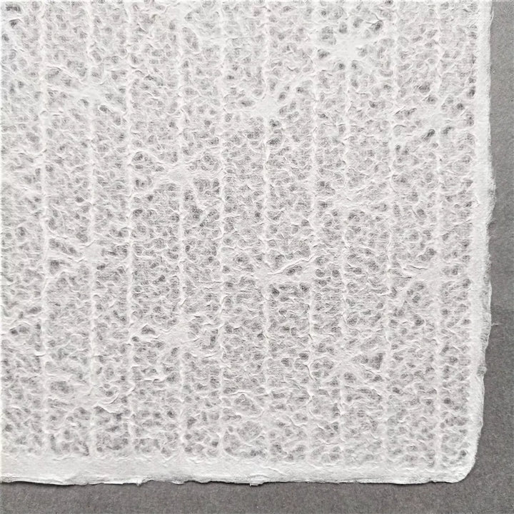 Intricately designed lace-style handmade paper from Kozo Studio using mulberry fibers, showcasing the Rakusui method