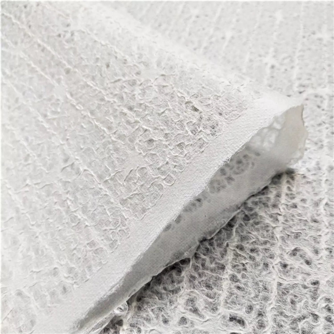 Elegant and translucent handmade mulberry paper with bow lace pattern, crafted at Kozo Studio for decorative and creative uses