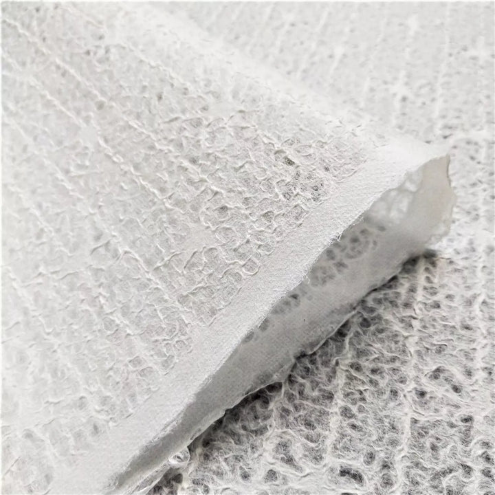 Elegant and translucent handmade mulberry paper with bow lace pattern, crafted at Kozo Studio for decorative and creative uses