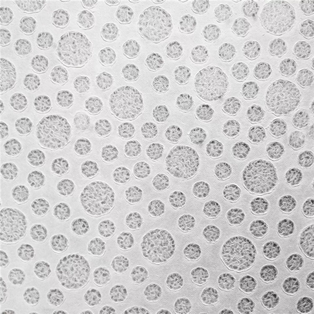 A close-up of the Handmade Lace Kozo Paper (Bubble) by Kozo Studio reveals a white textured mulberry surface with varying-sized raised circles. These slightly embossed textures create an overall dotted effect.