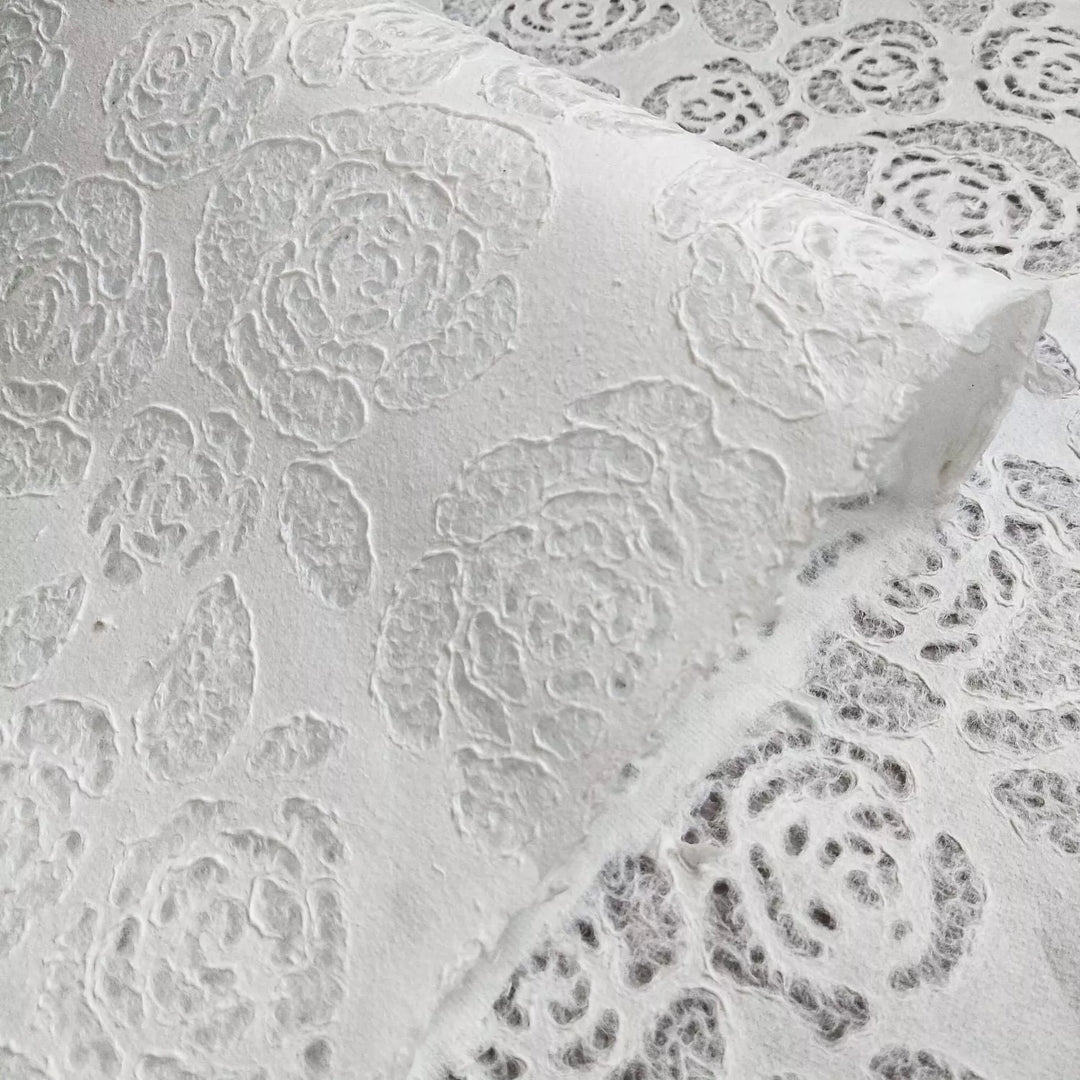 Translucent mulberry paper from Kozo Studio, adorned with intricate rose and leaf patterns, offering elegance for lampshades, crafts, and fashion detailing.
