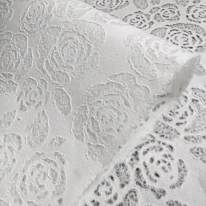 Translucent mulberry paper from Kozo Studio, adorned with intricate rose and leaf patterns, offering elegance for lampshades, crafts, and fashion detailing.