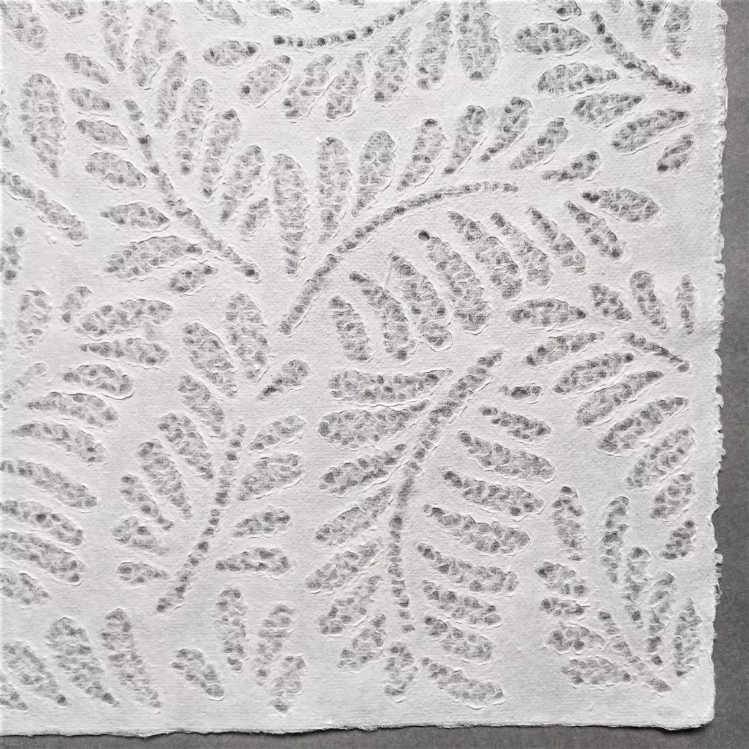 Artistic mulberry paper with lace-style fern design, handcrafted at Kozo Studio using traditional Rakusui techniques for unique handmade paper creations.