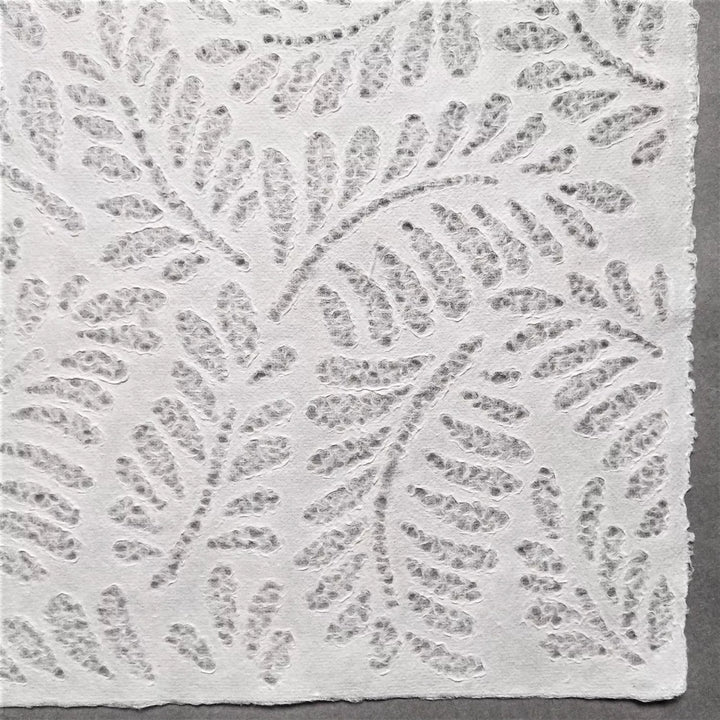 Artistic mulberry paper with lace-style fern design, handcrafted at Kozo Studio using traditional Rakusui techniques for unique handmade paper creations.