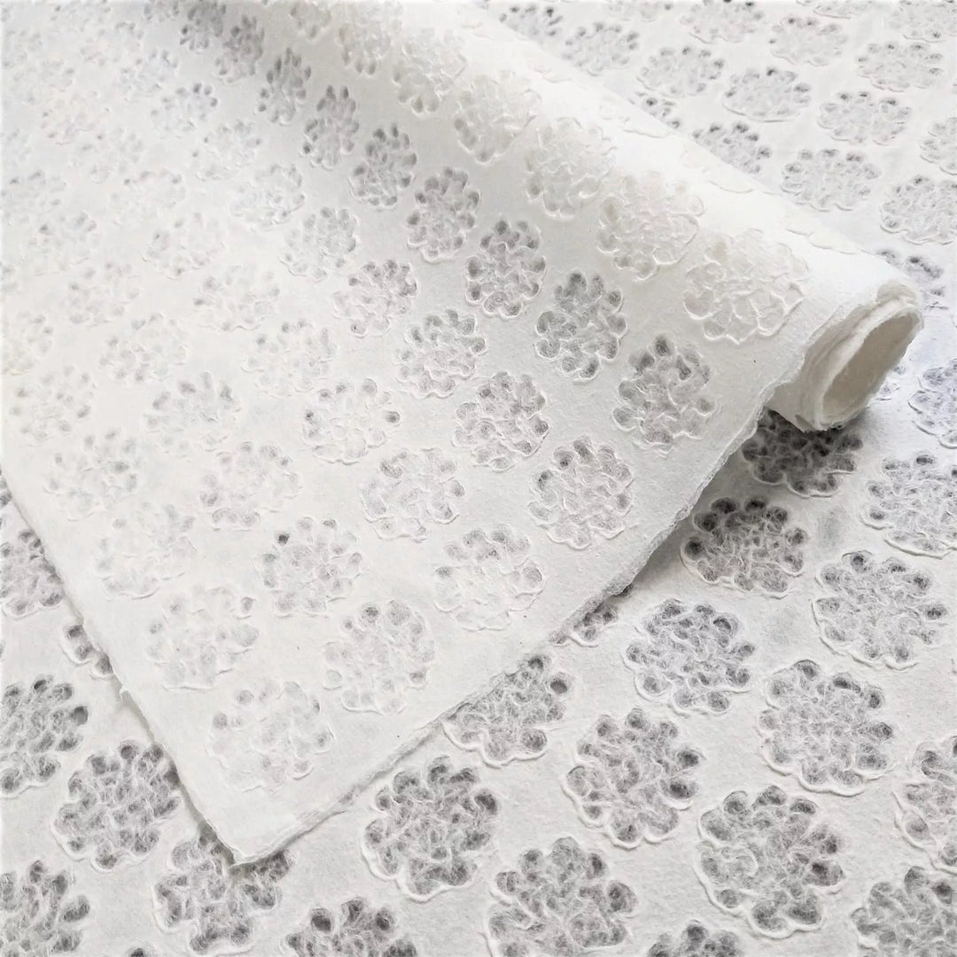 Unrolled Handmade Lace Kozo Paper by Kozo Studio featuring a delicate floral pattern and raised flower motifs on translucent mulberry paper.