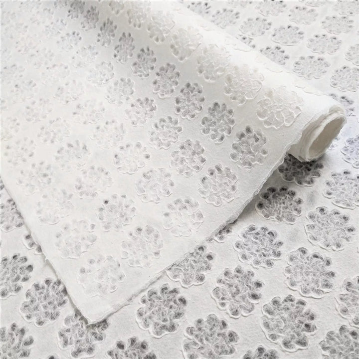 Unrolled Handmade Lace Kozo Paper by Kozo Studio featuring a delicate floral pattern and raised flower motifs on translucent mulberry paper.