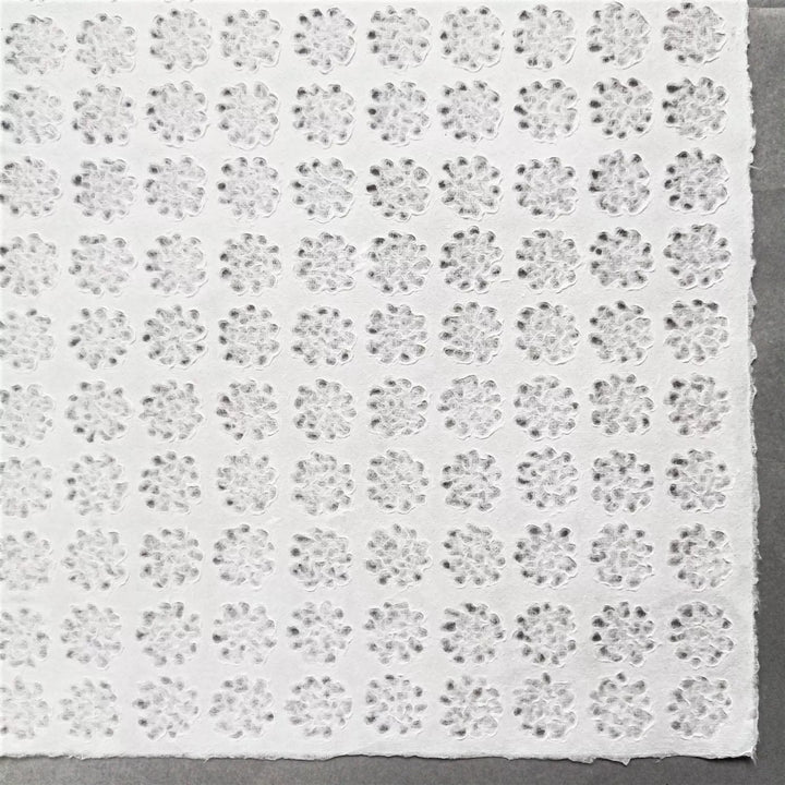A roll of Handmade Lace Kozo Paper unrolled to display its floral design, highlighting the translucent quality and craftsmanship of Kozo Studio's mulberry paper.