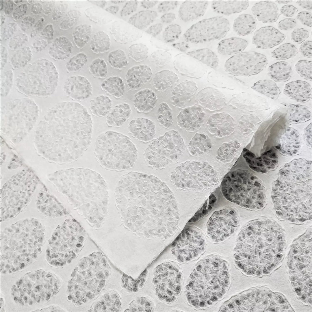 Close-up of handmade lace mulberry paper with a stone pattern, crafted by Kozo Studio using the Rakusui technique, ideal for lampshades and creative art projects.