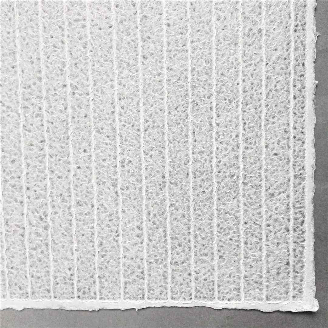 Zoomed-in view of striped lace mulberry paper by Kozo Studio, a handmade paper with elegant patterns formed by water manipulation for a delicate, translucent finish.