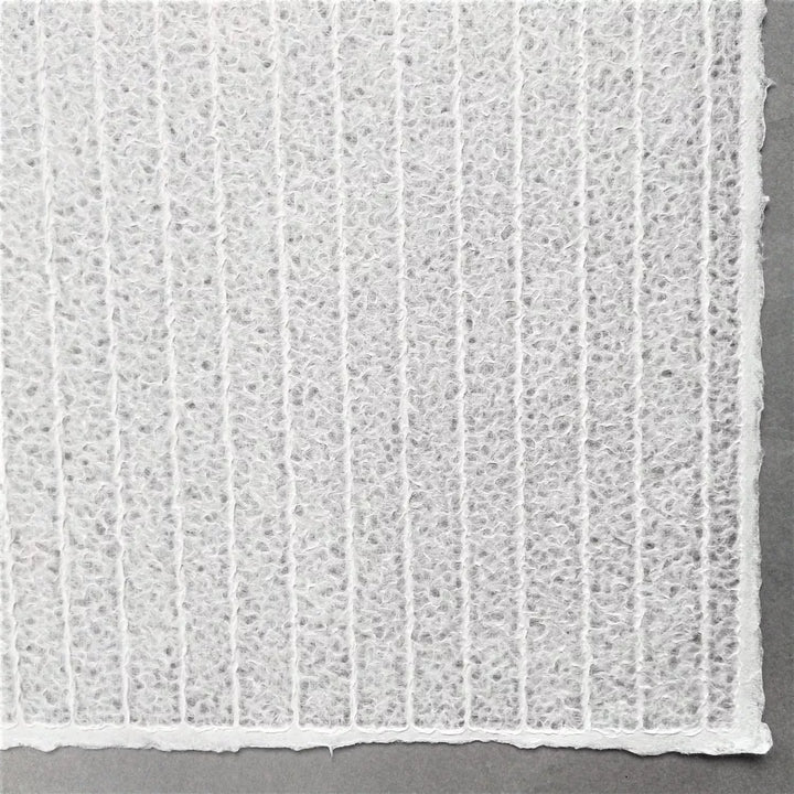 Zoomed-in view of striped lace mulberry paper by Kozo Studio, a handmade paper with elegant patterns formed by water manipulation for a delicate, translucent finish.