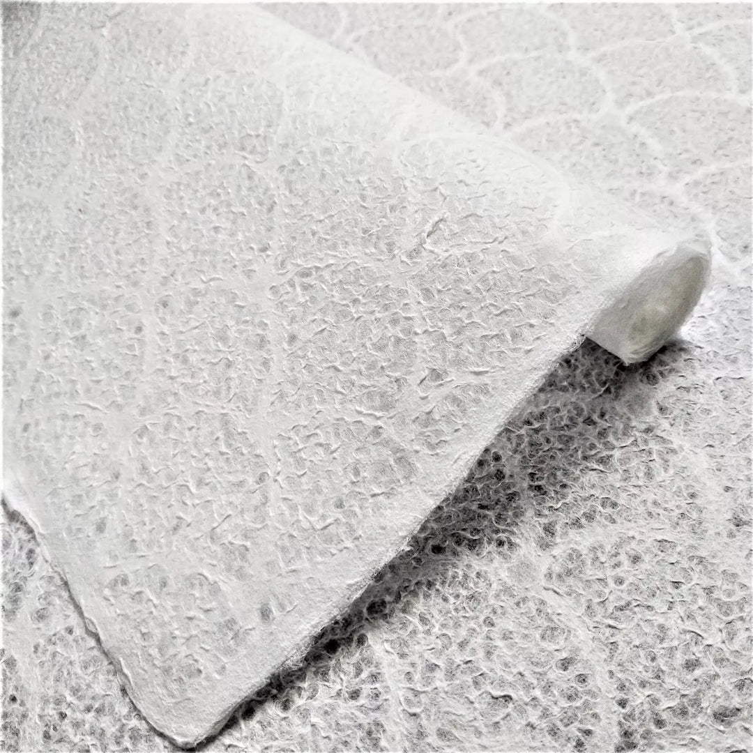 Close-up of textured wave pattern on handmade lace mulberry paper by Kozo Studio, highlighting its soft, translucent surface perfect for art projects.