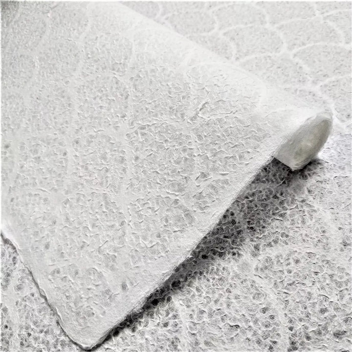 Close-up of textured wave pattern on handmade lace mulberry paper by Kozo Studio, highlighting its soft, translucent surface perfect for art projects.