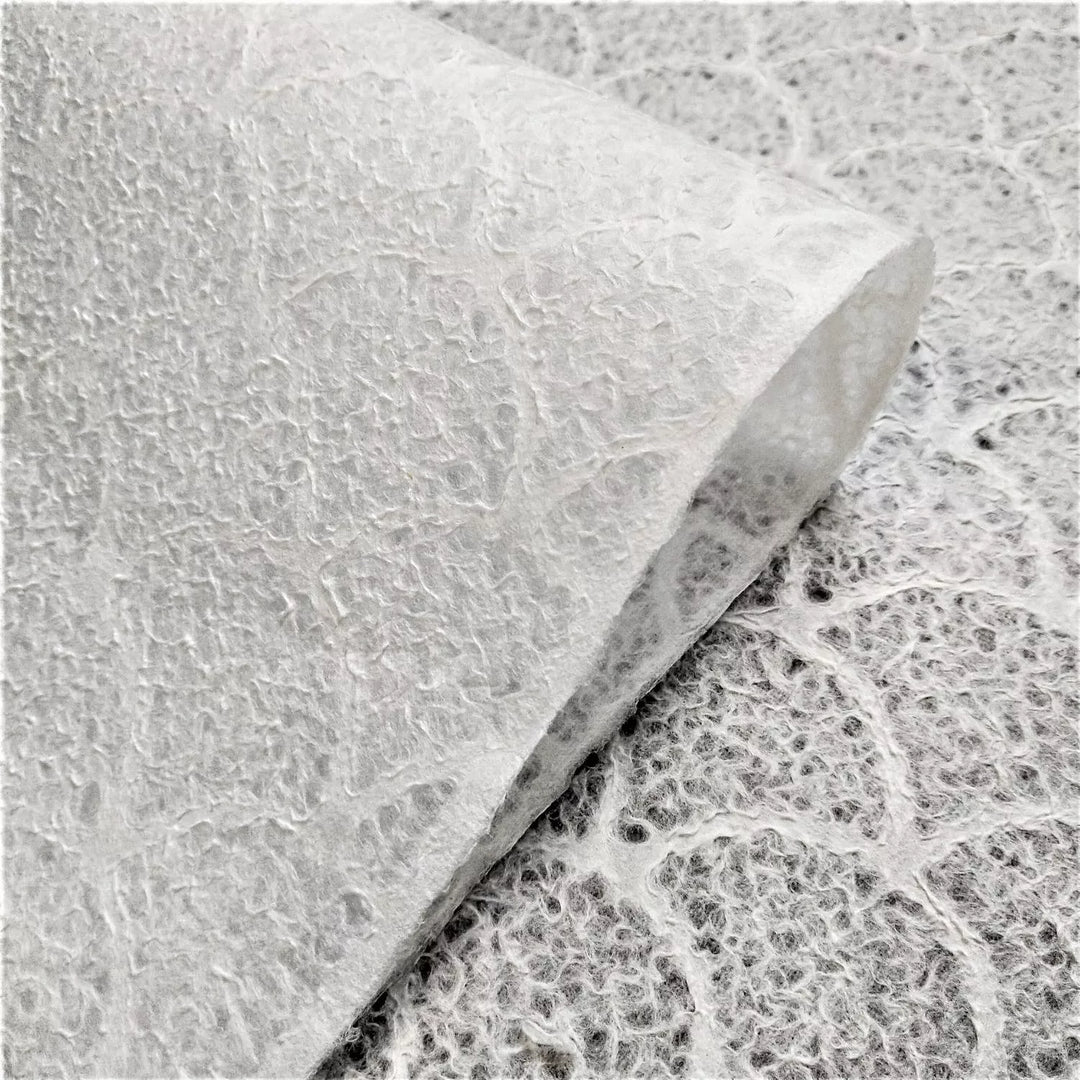 Elegant handmade paper with wave design crafted by Kozo Studio, made from mulberry paper known for its delicate translucency and texture.