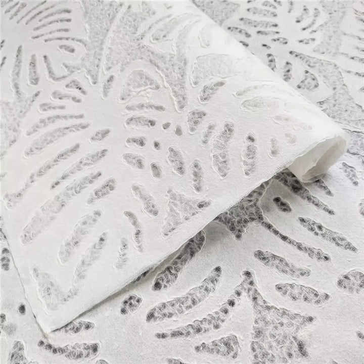 Close-up of white handmade mulberry paper from Kozo Studio featuring a delicate Monstera leaf design with translucent texture ideal for creative projects and lampshades.