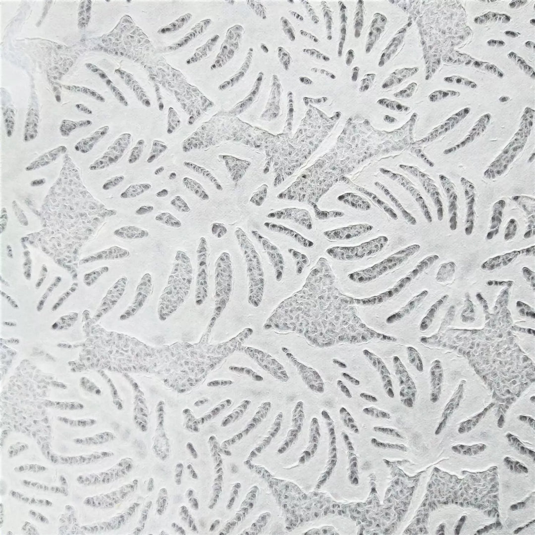 Artistic photograph of lace mulberry paper crafted by Kozo Studio, highlighting a Monstera leaf motif and delicate texture suitable for crafts, windows, or lighting.